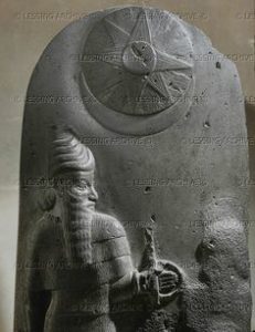 Top of a Mesopotamian stele, usurped by the Elamites. A god with orant (damaged). Sun- and moongod symbols above the figures. From Susa, Iran. Basalt, 63 x 40 cm Sb 10
