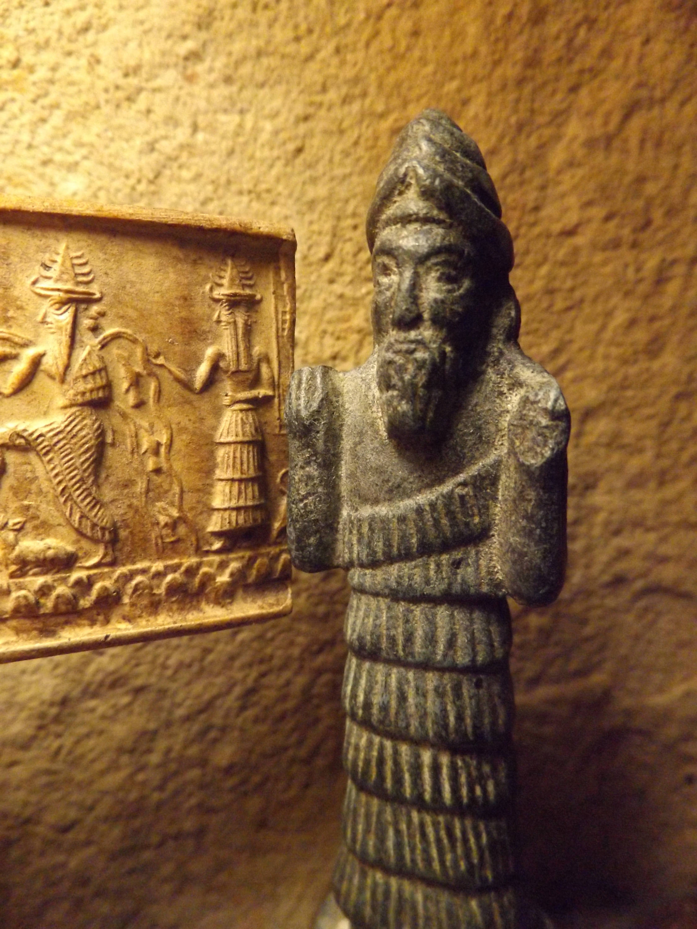 1c - Enki statue artifact with another Enki artifact on the wall; Enki was the oldest & wisest of the royal Anunnaki who came down to Earth, he was the sole keeper of the MEs, knowledge on discs